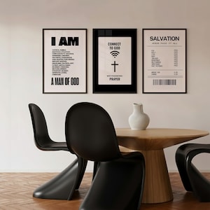 May include: Three framed art prints with black frames. The prints feature text: "I AM A MAN OF GOD", "CONNECT TO GOD, WIFI PASSWORD: PRAYER", and "SALVATION JESUS PAID IT ALL". The scene includes a wooden table, black chairs, and a white vase.