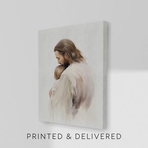 May include: A canvas print depicting a tender moment. The artwork features a figure in white robes embracing a child. The image has soft, muted tones and the text "PRINTED & DELIVERED" is at the bottom.