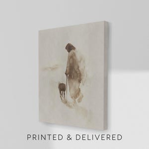 May include: Canvas art print featuring a sepia-toned watercolor painting of a figure with a staff and a sheep. The artwork has a minimalist style with soft edges and a muted color palette. The text "PRINTED & DELIVERED" is printed at the bottom.