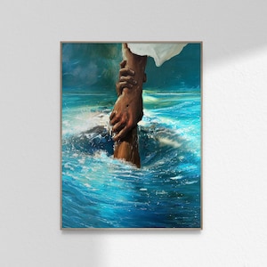 Puede incluir: Impresión artística enmarcada que representa una mano extendida hacia otra, emergiendo de agua azul turbulenta. La obra de arte se centra en las manos y el movimiento dinámico del agua, con una persona vestida de blanco.