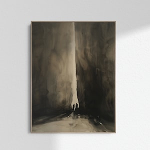 Op de afbeelding: Abstracte kunstprint in een houten lijst. Het kunstwerk heeft een donker, monochroom kleurenpalet met een centrale verticale lichtzone en silhouetten van figuren aan de onderkant. De stijl doet denken aan inktwassen.