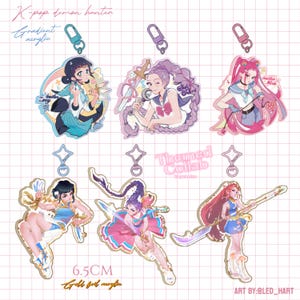 May include: Acrylic keychains featuring K-pop demon hunter designs. Each keychain showcases a colorful illustration of a character with a sword or weapon. The keychains are approximately 6.5 cm in size and have gold foil accents.