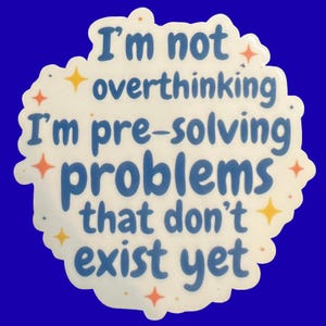 May include: A die-cut sticker with a white background and blue text that reads, I'm not overthinking I'm pre-solving problems that don't exist yet. The design is decorated with small orange and yellow four-pointed star shapes scattered around.
