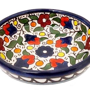 Könnte beinhalten: Eine kleine, runde Keramikschüssel mit weißem Hintergrund und einem bunten Blumenmuster. Die Schüssel hat einen blauen Rand und einen weißen und blauen Musterrand.
