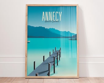 May include: A framed poster featuring a blue and green illustration of a lake and a wooden pier. The text "Annecy Haute-Savoie" is at the top of the poster.