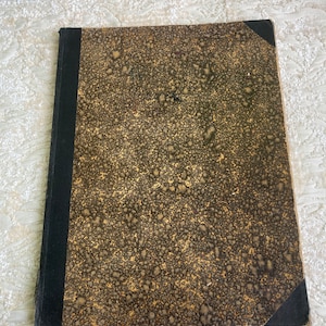 May include: A vintage, brown leather-bound journal with gold flecks and black edges. The cover is worn and has a speckled pattern.