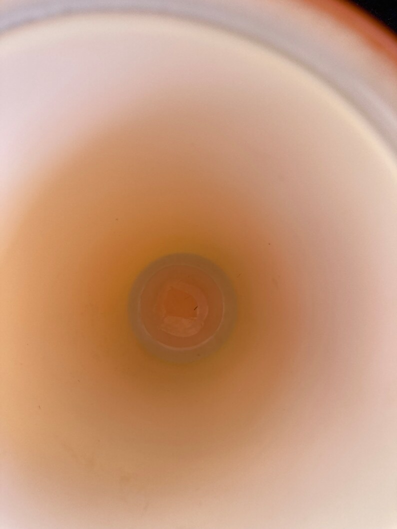May include: A white ceramic mug with a smooth, glossy finish. The inside of the mug is visible, showing a light brown color.