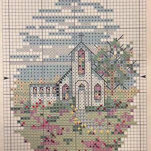 Puede incluir: Un patrón de punto de cruz que representa una iglesia con campanario, rodeada de árboles y flores. El diseño utiliza varios colores, incluyendo blanco, rosa, verde y azul, creando una imagen detallada y texturizada. Las palabras "Easter Sunday" están en la parte inferior.