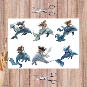 May include: A set of watercolour illustrations showing mermaids riding dolphins. The mermaids have long, flowing hair and are in different poses. The dolphins are shades of blue and white. The background is a wooden surface with art supplies.