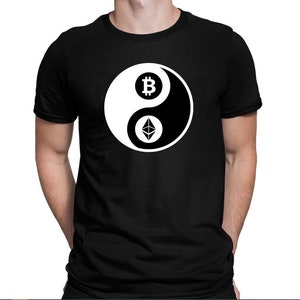 Op de afbeelding: Zwart T-shirt met een wit yin yang symbool. De yin-kant heeft een Bitcoin-symbool en de yang-kant heeft een Ethereum-symbool.