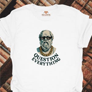 May include: A white t-shirt featuring a graphic of a classical bust of Socrates wearing pixelated black sunglasses and a gold chain. Below the bust, the text reads "QUESTION EVERYTHING" in dark green capital letters. The brand logo is at the neck.