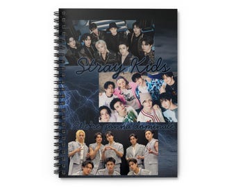 May include: Spiral-bound notebook featuring a collage of images of the musical group Stray Kids. The cover has a dark blue background with lightning bolt graphics and the text "Stray Kids" and "We're gonna dominate" in a script font.