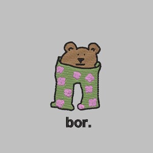 May include: A brown bear wearing green pants with pink polka dots. The text "bor." is below the bear.