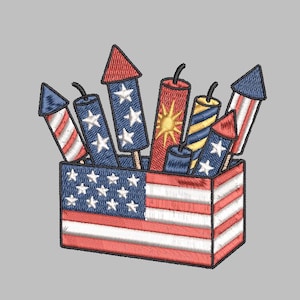 May include: Embroidered design of a box filled with fireworks. The box is decorated with the American flag. The fireworks are red, white, and blue, with star and stripe patterns. The design is on a gray background.