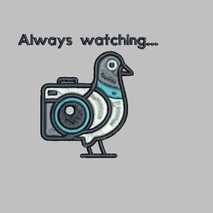 Puede incluir: Diseño bordado que presenta una paloma con una lente de cámara en lugar de un ojo, en tonos grises, turquesa y negro. El texto "Always watching..." está encima del pájaro. El diseño está sobre un fondo gris claro.