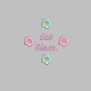 May include: Embroidered design featuring the phrase "Eat Glass" in pink script, surrounded by four embroidered flowers. The flowers alternate between light blue and pink, each with a yellow center, set against a gray background.