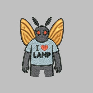 Puede incluir: Diseño bordado de una criatura gris con forma de polilla con alas naranjas. La criatura lleva una camiseta azul claro con las palabras "I ❤️ LAMP" en negro y un corazón rojo. El diseño está sobre un fondo gris.