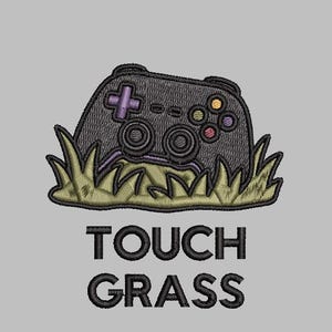 May include: An embroidered patch featuring a black video game controller nestled in green grass. The controller has a purple directional pad and colorful buttons. Below the graphic, the text TOUCH GRASS is embroidered in bold black capital letters.