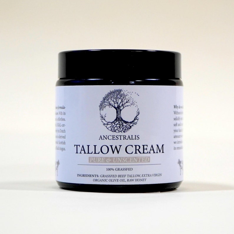 Peut inclure: Un pot blanc avec un couvercle noir et une &eacute;tiquette qui indique "ANCESTRALIS TALLOW CREAM PURE & UNSCENTED 100% GRASSFED INGREDIENTS: GRASSFED BEEF TALLOW, EXTRA VIRGIN ORGANIC OLIVE OIL, RAW HONEY". L'&eacute;tiquette pr&eacute;sente &eacute;galement un arbre avec des racines et un cercle autour.