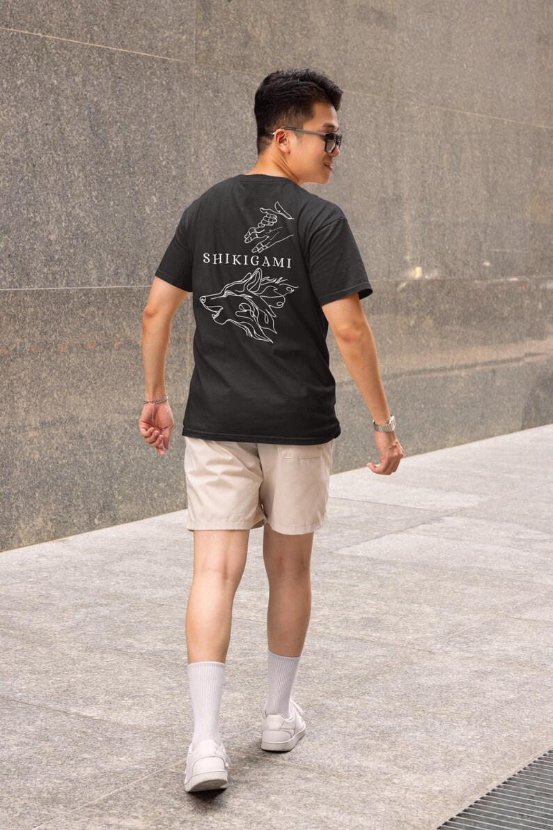 May include: A black t-shirt with a white graphic design of a wolf's head with flames and the text "SHIKIGAMI" on the back.