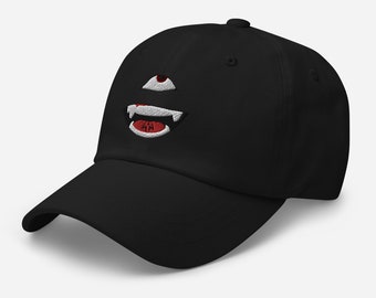 May include: Black baseball cap with an embroidered white and red design of a face with a single eye and fangs.