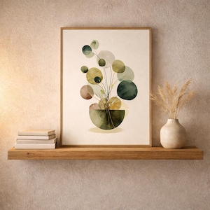 May include: A framed watercolor print of a plant with circular leaves in shades of green, brown, and yellow. The print is in a wooden frame and sits on a wooden shelf with a stack of books and a vase with dried grass.