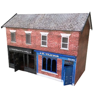 May include: A model of a brick building with two storefronts. The storefront on the left says "Pentreat & Hall" and the storefront on the right says "F.W. Traynor Est. 1800".