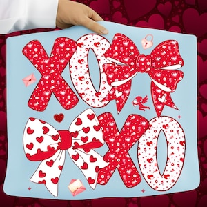 May include: A light blue pillow with the letters "XOXO" in red and white, decorated with bows, hearts, and floral patterns. A small cupid, a lock, and two envelopes are also featured in the design.