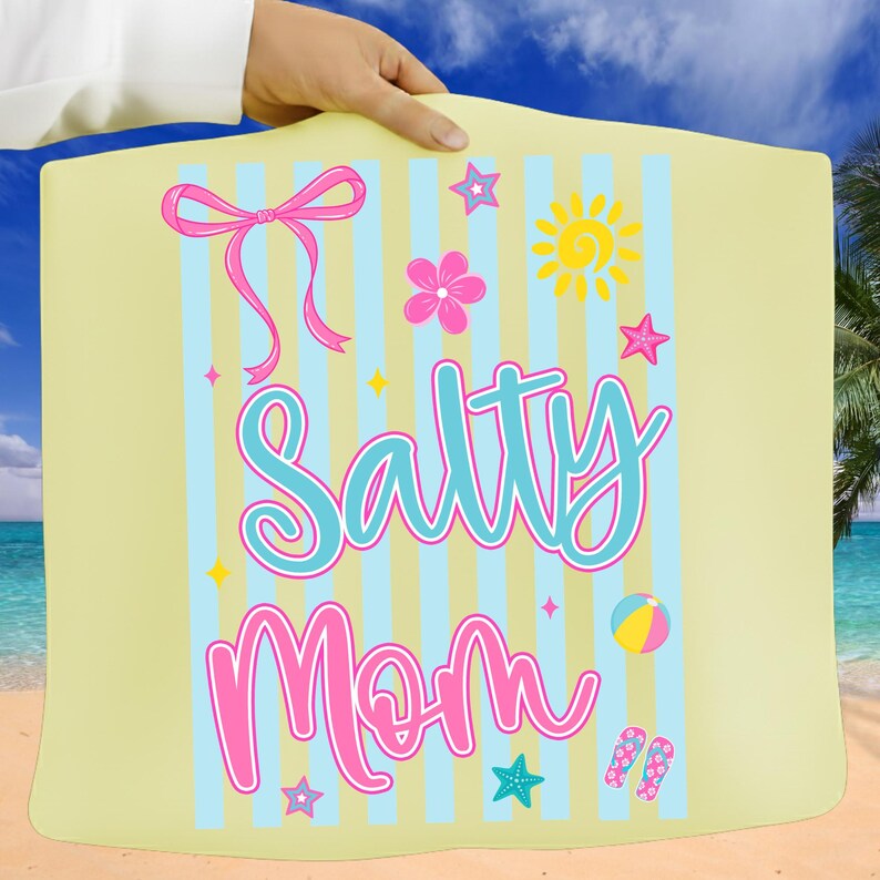 Pu&ograve; includere: Un telo da mare giallo chiaro con strisce blu e bianche. Il telo presenta le parole "Salty Mom" in corsivo turchese e rosa, insieme a grafiche a tema spiaggia come un sole, stelle e un pallone da spiaggia.