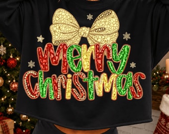 Może przedstawiać: Czarna bluza z długim rękawem z grafiką dużej złotej kokardy nad napisem Merry Christmas w kolorach czerwonym, zielonym i żółtym o fakturze fasetowanych kamieni szlachetnych. Dookoła wzoru rozmieszczone są małe białe ikony płatków śniegu.