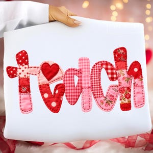 Pode incluir: Almofada branca com a palavra "teach" aplicada em tecidos vermelhos e rosa. As letras são um patchwork de bolinhas, xadrez, estampas florais e lisas, com um coração substituindo a letra "a".