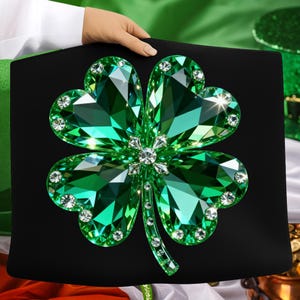 May include: A black decorative item featuring a large, sparkling green shamrock design. The shamrock is adorned with numerous clear, round crystals, creating a dazzling effect. The shamrock is held by a person.