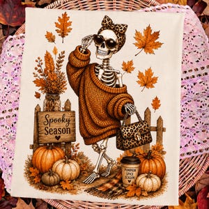 May include: A cream-colored fabric featuring a skeleton wearing a brown knit sweater, leopard print headband, and sunglasses. The skeleton holds a leopard print handbag. Text reads Spooky Season and Pumpkin Spice Season near pumpkins and autumn leaves.