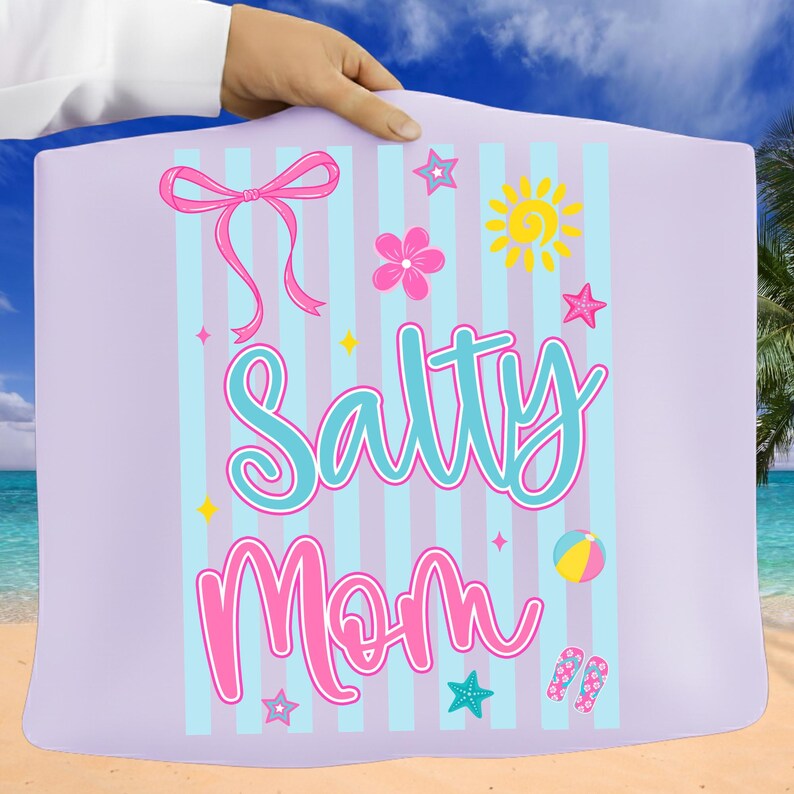 Pu&ograve; includere: Un telo da mare lilla chiaro con strisce blu verticali e le parole "Salty Mom" in corsivo turchese e rosa. L'asciugamano presenta un fiocco rosa, un fiore, un sole, stelle, un pallone da spiaggia e infradito.