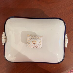 May include: White porcelain serving dish with a blue rim and a gold floral design on the lid.