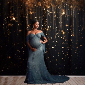 May include: A pregnant person wearing a long, flowing, dark blue sequined gown with an off-the-shoulder neckline. The person is standing in front of a black backdrop with gold glitter and stars.