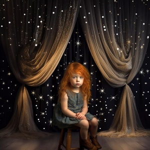 May include: A young girl with long, red hair sits on a wooden stool in front of a black and gold curtain with white glitter stars. She is wearing a blue dress and has a serious expression on her face.