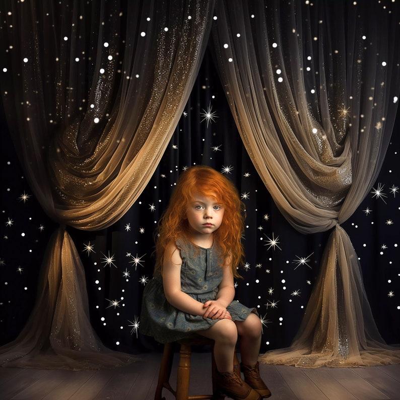 May include: A young girl with long, red hair sits on a wooden stool in front of a black and gold curtain with white glitter stars. She is wearing a blue dress and has a serious expression on her face.