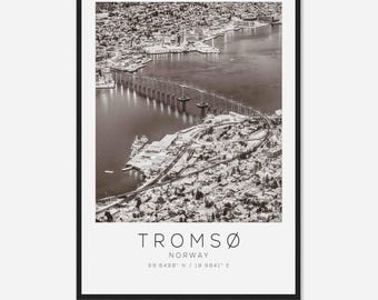 May include: A black and white aerial photograph of Tromsø, Norway. The city is covered in snow and a bridge crosses a body of water. The text "Tromsø, Norway 69.6498° N / 18.9841° E" is printed below the image.