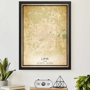 May include: A vintage-style map print of Lima, Ohio, with a black frame. The map is in shades of green and brown, with the city's streets and landmarks clearly marked. The text "Lima, Ohio 40.7419°N / -84.1162°E" is printed at the bottom of the map.