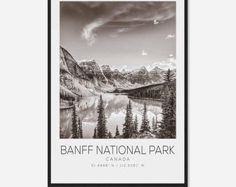 May include: A black and white photograph of Banff National Park in Canada. The image shows a mountain range with a lake in the foreground. The text "Banff National Park, Canada, 51.4968° N / 115.9281° W" is at the bottom of the image.