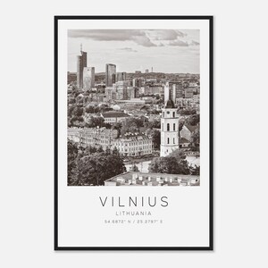 Puede incluir: Impresión enmarcada en blanco y negro de Vilna, Lituania. La imagen muestra un paisaje urbano con edificios, una torre de iglesia y árboles. El texto "VILNIUS" está en la parte inferior, junto con "LITHUANIA" y coordenadas.