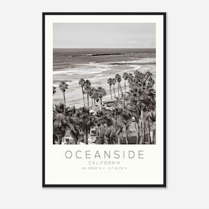 Könnte beinhalten: Schwarzweißfoto von Oceanside, Kalifornien. Das Bild zeigt einen Strand mit Palmen und einen Pier in der Ferne. Der Text "OCEANSIDE CALIFORNIA 33.2260°N / -117.3175°E" ist unter dem Bild gedruckt.