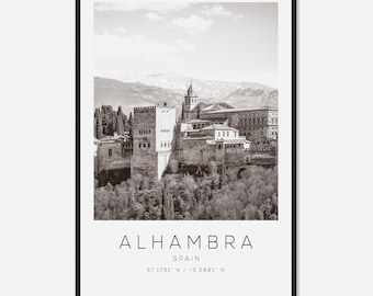 May include: Black and white framed print of the Alhambra in Spain. The image features the historic fortress with text that reads "ALHAMBRA SPAIN 37.1761° N / -3.5881° W". The print is set against a backdrop of mountains and trees.