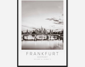 May include: Black and white photograph of the Frankfurt skyline with a bridge in the foreground. The text "FRANKFURT GERMANY 50.1109° N / 8.6821° E" is below the image.