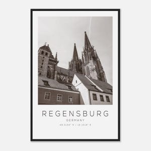 Könnte beinhalten: Schwarz-Weiß-Druck mit Sepia-Ton, der Regensburg, Deutschland, zeigt. Das Bild zeigt eine Kathedrale mit hohen Türmen und detaillierter Architektur. Der Name der Stadt und die Koordinaten sind unter dem Bild aufgedruckt.