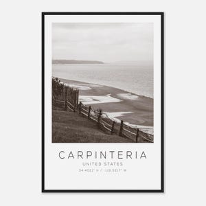 May include: Black and white framed print featuring a coastal landscape with a beach, ocean, and a wooden fence. The print includes the text "CARPINTERIA, UNITED STATES" and coordinates 34.4021° N / -119.5217° W.