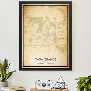 May include: A vintage-style map print of Casa Grande, Arizona, with a black frame. The map shows the city's streets and landmarks in a faded green and brown color scheme. The text "Casa Grande, Arizona, 32.8871°N / -111.7612°E" is printed at the bottom of the map.