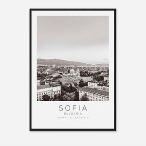 May include: A black and white aerial photograph of Sofia, Bulgaria. The photo shows the city skyline with a large church in the center. The text "SOFIA" and "BULGARIA" is printed below the image, along with the coordinates "42.6977° N / 23.3219° E".