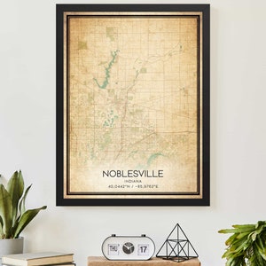 May include: A vintage-style map print of Noblesville, Indiana, with a black frame. The map is in shades of brown and green, with the city name and coordinates printed at the bottom.